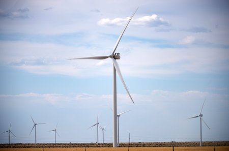 Wind turbines generating renewable energy in motion. P Wind turbines producing electricity from...