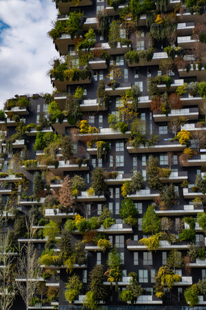Green building with trees represents modern architecture in Milan. Bosco Verticale skyscraper. Sustainable architecture. Vertical forest tower in Italy. Modern apartments by greenery.の写真素材