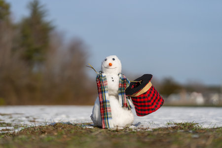 Snowman wait spring. Snowman is melting on spring day. Winter and spring, warm winter. Melted snow, winter weather, anomaly weather concept. Spring time. Winter season.の写真素材