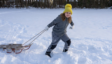 Kid play in snow. Active winter day for kids. Childhood in winter. Sledding kid theme. Winter kid...