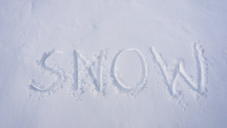 Winter text on snowy background. Snowy print design for winter. Frosty winter text outdoors. Winter text with snowflakes. Icy background with snow banner. Snowy field with snow print.の写真素材