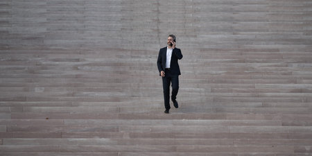 Businessman step up upward on stairs. Man stepping toward professional growth and success. Step by step toward career achievement. Business man climbing stairs. Step to business goals.の写真素材