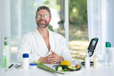Male beauty facial treatment for healthy skin. Mature man using facial cosmetic products to enhance facial beauty. Man practicing facial care for a beauty routine. Aged male skin concept.の写真素材