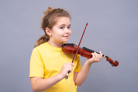 Kid with violin practices melody. Child play violin isolated studio background. Kid learns music. Teen with violin feels harmony. Classic music for kids. Violin child lesson.の写真素材