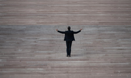 Business man walking up stairs as a symbol of career growth and success. Business step. Future goal and victory. Guy on stairs. Man climbing on stairs. Man in a suit moving up stairs. Goal concept.の写真素材