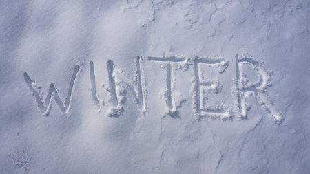 Winter text on snowy background. Winter text with snowflakes. Icy background with snow banner. Snowy field with winter print.の写真素材