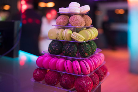 Colorful macarons and desserts on elegant buffet table. Luxury sweets and desserts served at festive...