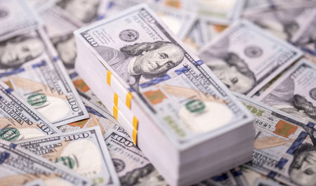 Stack of dollars and cash with a money background. US dollars money and banknotes. Pile of 100 USD...