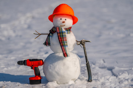 Cute snowman in winter gear with tools.の写真素材