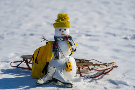 Snowman with luggage ready for holiday trip. Winter vacation starts with snowman. Christmas snowman...