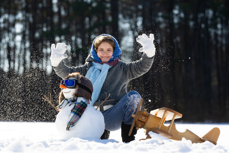 Kids enjoying winter. Child play in snow. Child throwing snow outdoors. Young kid with winter gloves. Children play in snowy winter. Child in winter holiday scene. Kids having fun on snowy day.の写真素材
