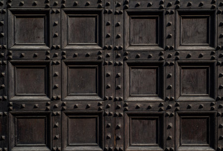 Antique wooden door pattern. Vintage brown door with geometric texture. Old wooden architecture and decorative surface. Square pattern panels on ancient building door. Vintage design.の写真素材