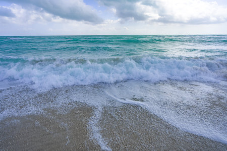 Ocean waves background. Tropical ocean waves. Blue seaside view. Foamy beach coastline. Sandy shore...