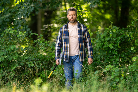 Lumberjack in the woods with an axe. Bearded man in hat with a hatchet. Lumberjack man with beard...