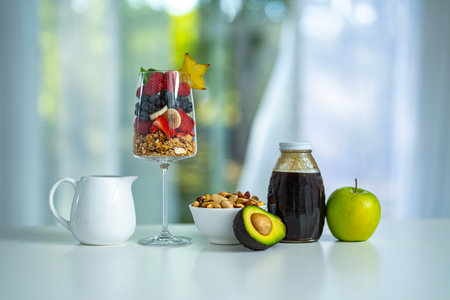 Fresh fruit mix in a glass for breakfast. Granola and muesli blend with berries and milk. Morning...