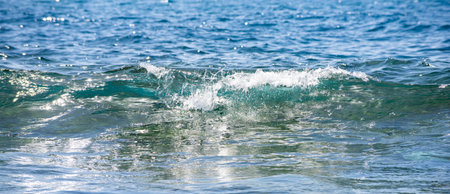 Rolling sea waves movement. Wave background. Soft sea waves. Abstract ocean texture. Transparent sea waves with foam sparkle.の写真素材