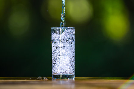 Pouring clean water in glass. Fresh water pour. Healthy hydration concept with pouring fresh water.