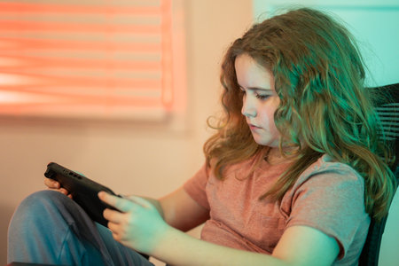 Child playing video game with joystick. Child using game controller playing video console game....