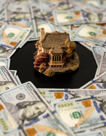 Buying a new home concept with house model and dollars money. Mortgage for a new house. Real estate...