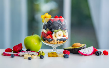 Healthy Mix Fruits with Tropical Berries and Natural Vitamins. Healthy Breakfast with Fresh Fruits and Granola in Glass. Morning with Superfood Fruits.の写真素材