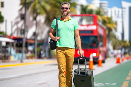 Man 40s traveler. Tourist on summer vacation. The travelers luggage for summer trip. Summer tour. A tropical getaway. Spring break. A traveler enjoys summer day. Spring trip.の写真素材