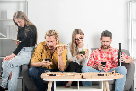 Friends sit together but all look at their phones. Group friends with social media concept. Group of...