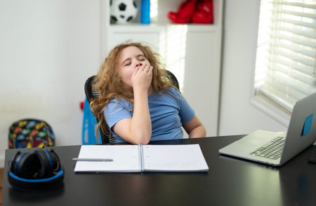 Bored child losing motivation to study. Bored kid stretching arms while studying at home. Bored...
