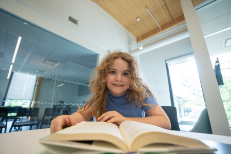 Child reading book at library. Kid studying and reading. Smart kid read book. Little student...