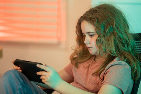Gamer kid portrait. Kid gamer looking at the screen. Gaming at home. Kid using a game console. Child...