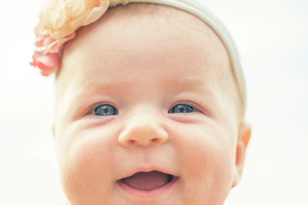 Smiling baby portrait lose up. Cute baby face with blue eyes. Happy baby. Newborn baby portrait.