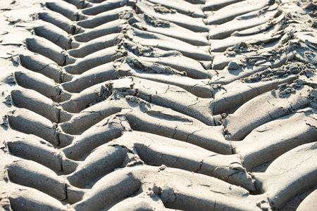 Tire track on sand shows fresh vehicle movement. Tire track reveals offroad driving sand path. Tire...