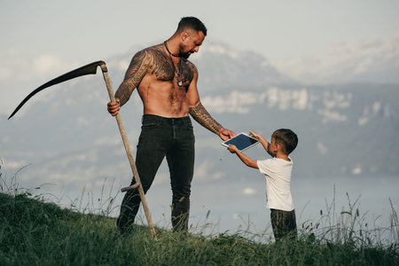 Farmers father and his son work together on farm field. The father teaches his child how to farm....