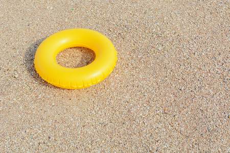 yellow inflatable paddling circle in the sand near the seaの写真素材