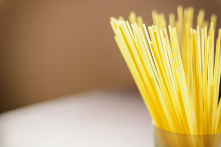 Long spaghetti in a transparent glass on a dark backgroundの写真素材