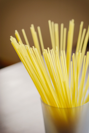 Long spaghetti in a transparent glass on a dark backgroundの写真素材