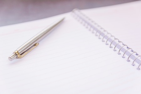 Notebook with Blank sheet of paper and Pen on wooden table backgroundの写真素材