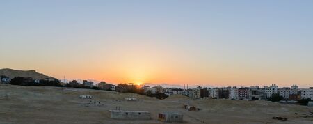 city on the edge of the desert during the evening twilightの写真素材