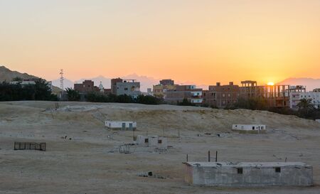 city on the edge of the desert during the evening twilightの写真素材