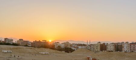 city on the edge of the desert during the evening twilightの写真素材