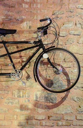 bike with shadow placed in front of a brick wallの写真素材