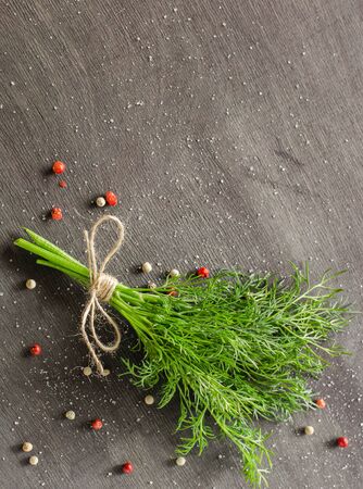 A bunch of fresh dill on dark wood background. Empty space for text.の写真素材