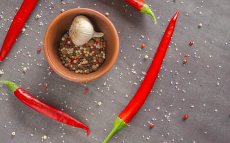 Several burning red peppers round bowls with spices in a dark table. View from above.の写真素材