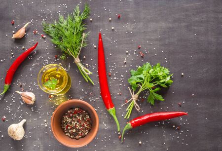 Parsley dill pepper and garlic in a dark wooden table. View from above. Space for text.の写真素材