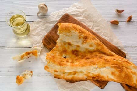 broken half pita bread caucasian, lying on a cutting board. Light wood background. Top view angle of 45 degrees.の写真素材