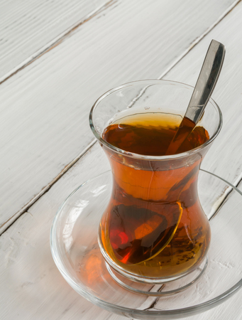 Transparent cup of thin glass and black tea. Spoon into a glass. Empty placeの写真素材
