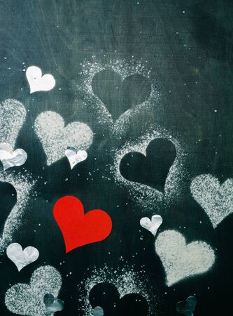 Card for Valentine's Day. Red paper heart on a rope. Strict dark background.の写真素材