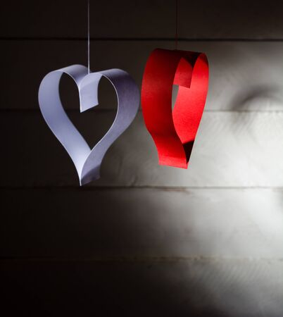 Postcard to Valentines Day. White and red heart made of paper strips. Dark background.の写真素材