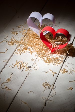 Postcard to Valentine's Day. White and red heart made of paper strips. White background. Country for text.の写真素材