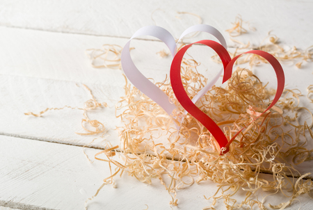 Postcard to Valentine's Day. White and red heart made of paper strips. White background. Country for text.の写真素材