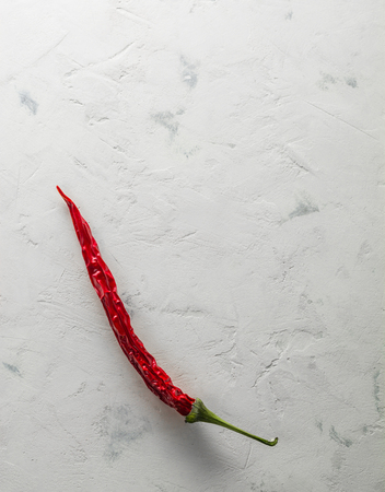 Red hot pepper pod dry. Bright stone background. Space for text.の写真素材